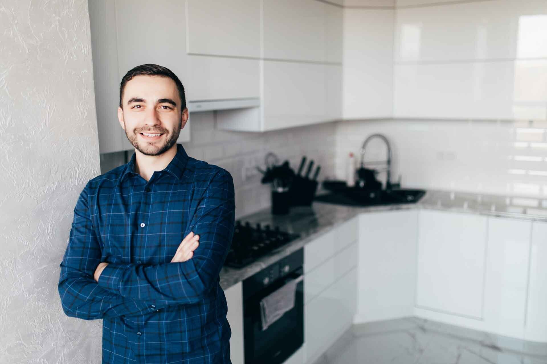 smiling man with folded arms in kitchen