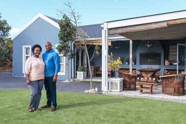 Happy couple in front of their home