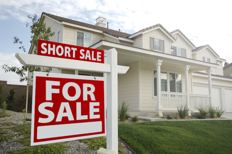 House in Dallas with short sale for sale sign in yard