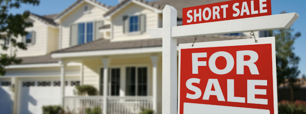 short sale sign in front of a white house