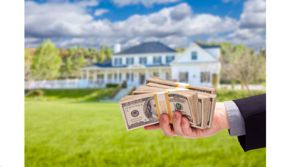 A hand holding cash in front of a white house.