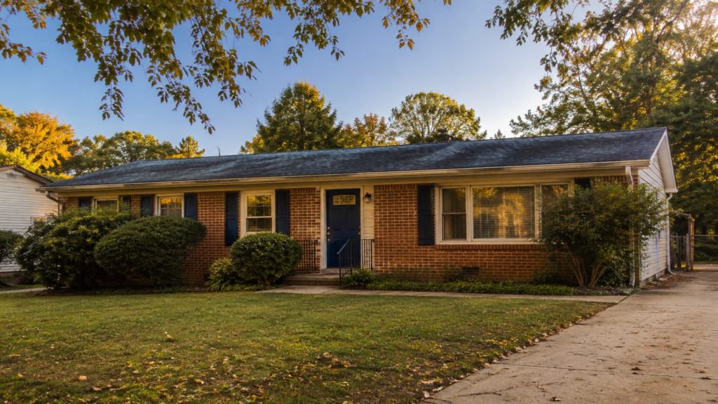 Single-story brick ranch home in a Charlotte, NC neighborhood with mature landscaping and a navy front door.