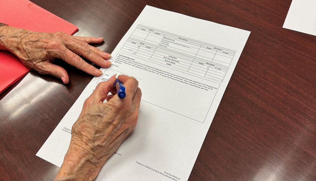 Seller is signing closing documents at attorney's office.