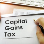 Hands holding documents with title capital gains tax