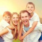 Happy young family with two children on wheat summer field