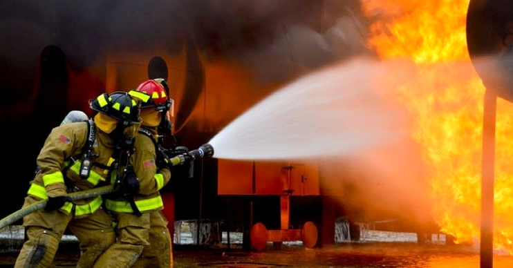 Two firefighters are putting out the fire.