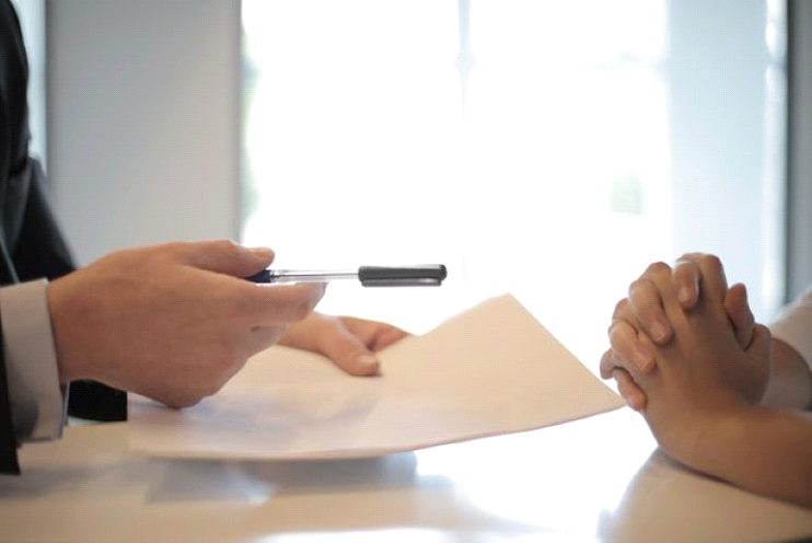 One person is giving a contract to another.