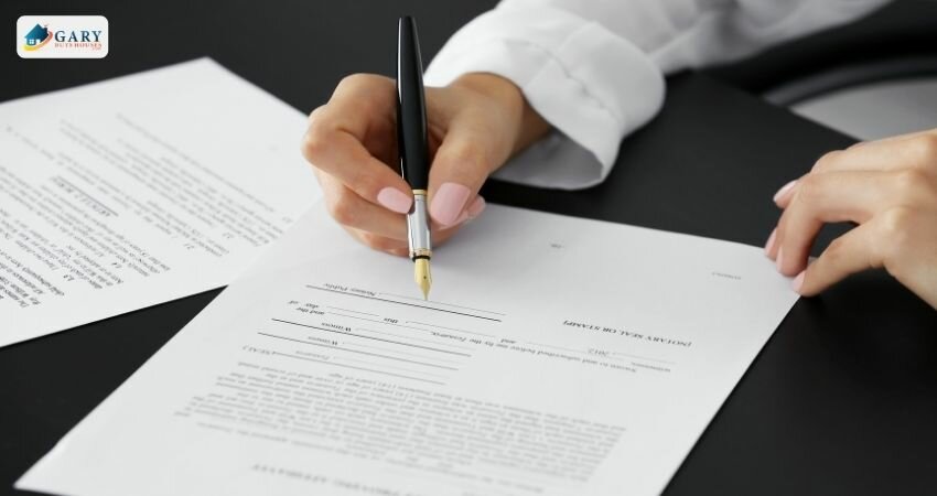 woman signing a document at a table