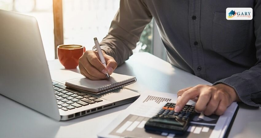 A picture of a man holding a pen and writing: computing the cost of closing.