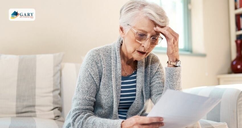 A senior woman holding papers looking stressed while looking at the documents