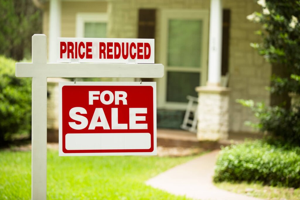 A red for sale sign in front of a nice home that was inherited.