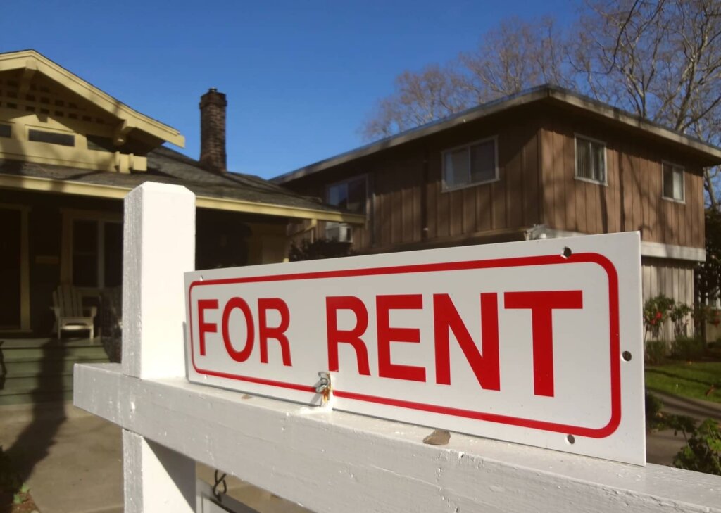 A red for rent sign in front of an older home that was inherited.