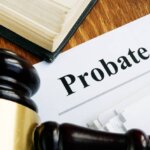The corner of a book, a gavel and a paper that says probate process.
