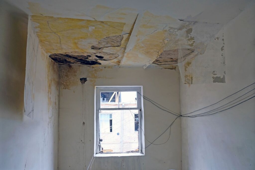 A ceiling and walls with damaged sheetrock from water.