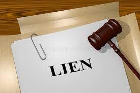 A file folder with a piece of paper, paper clipped to the front saying "lien"