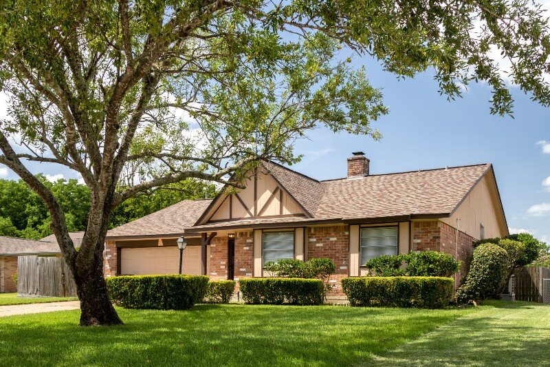 A one-story house in a typical suburban neighborhood in Texas.
