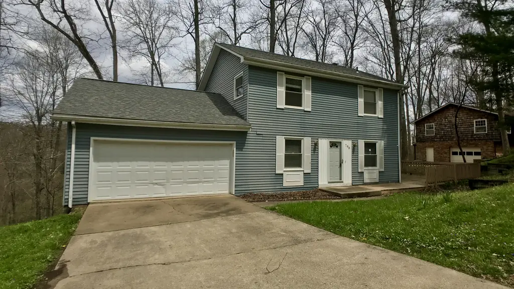 Front of the Seneca Hills house in Elkview before work, with blue siding and a garage