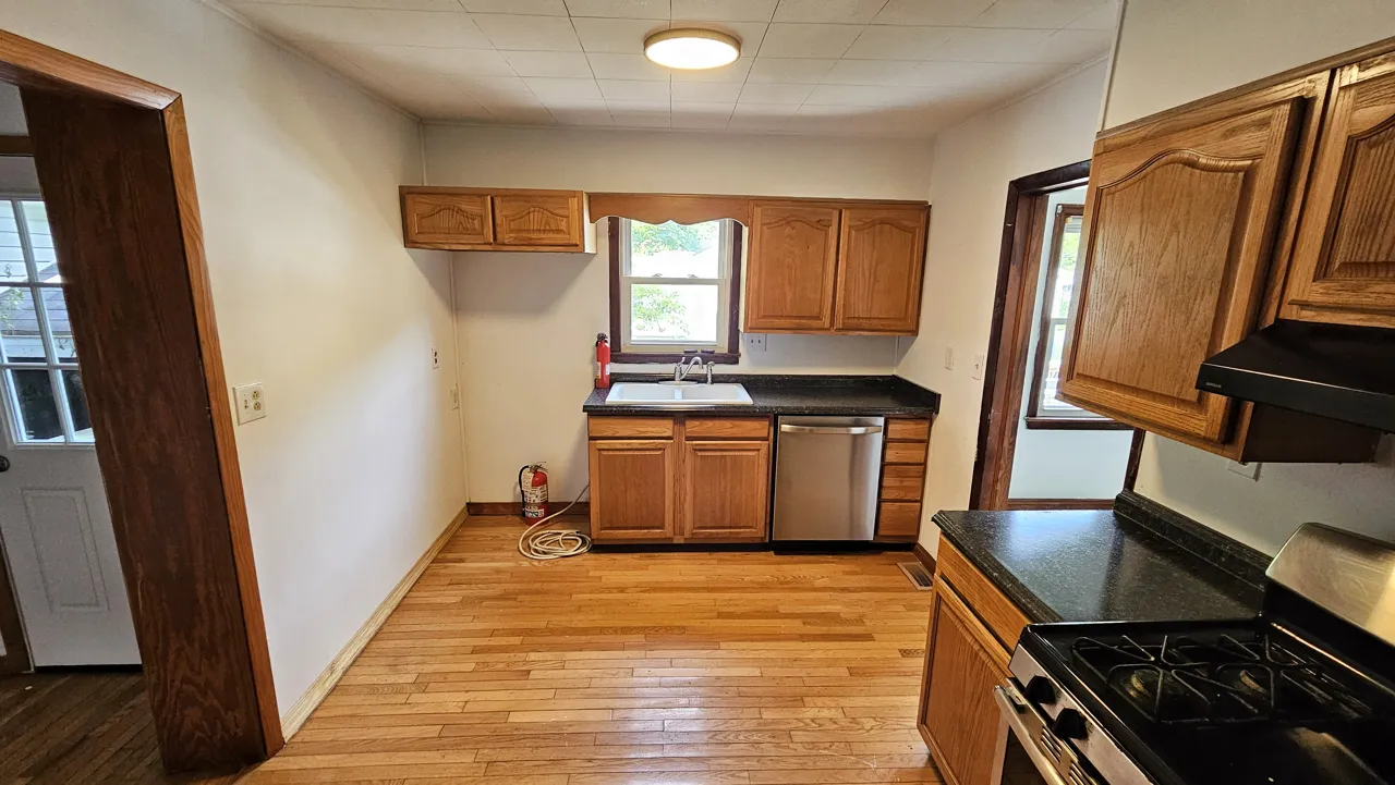 Same Georges Creek kitchen in June 2024 with painted walls, dark counters and a stainless dishwasher