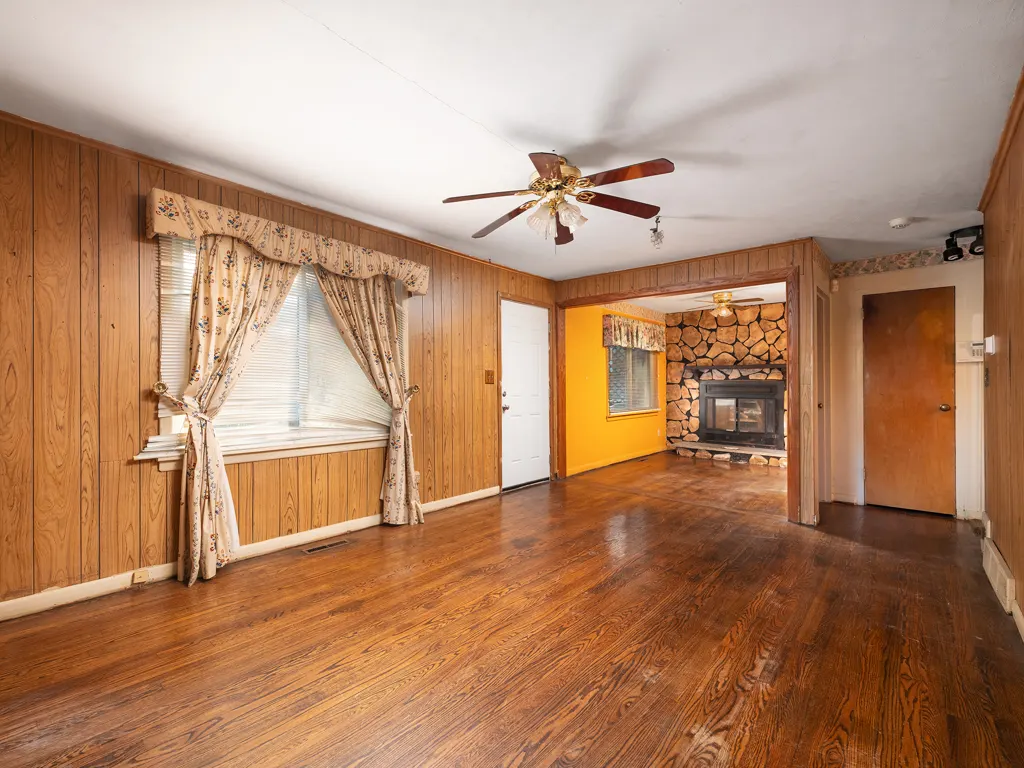 King Street living room in the later project photos, with wood flooring and a stone fireplace