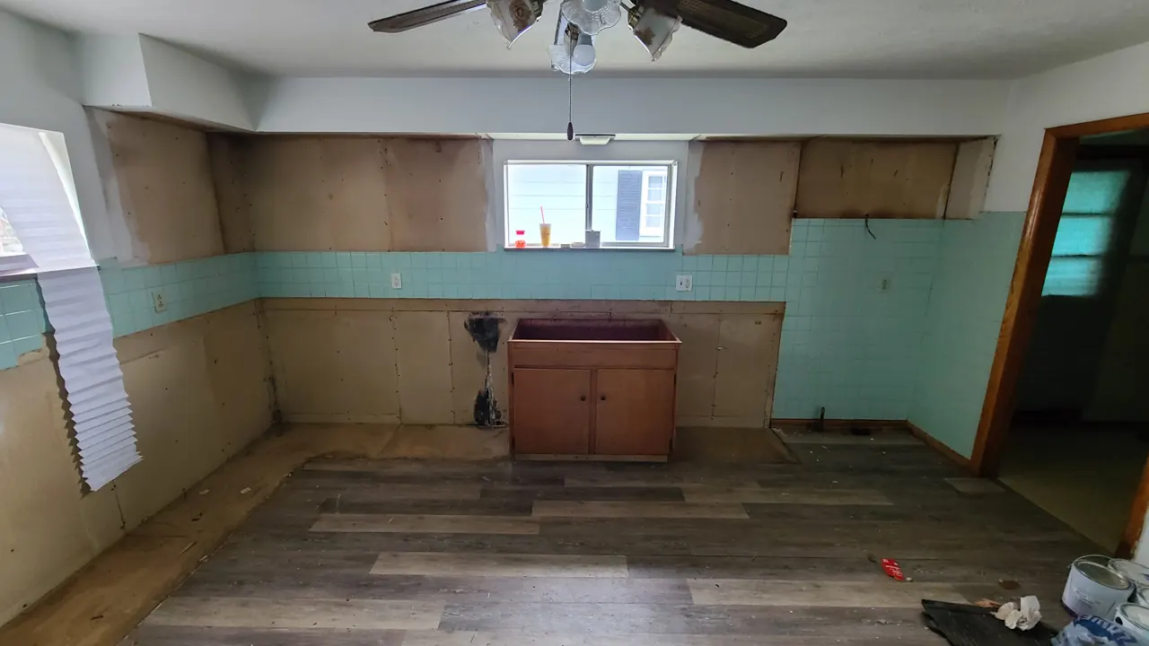McKinley Avenue kitchen during early renovation, with cabinets removed around the window