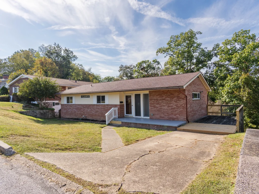 The same brick house at 1212 Crown Drive in South Charleston, WV, after work, showing the refreshed front porch and new wood deck section