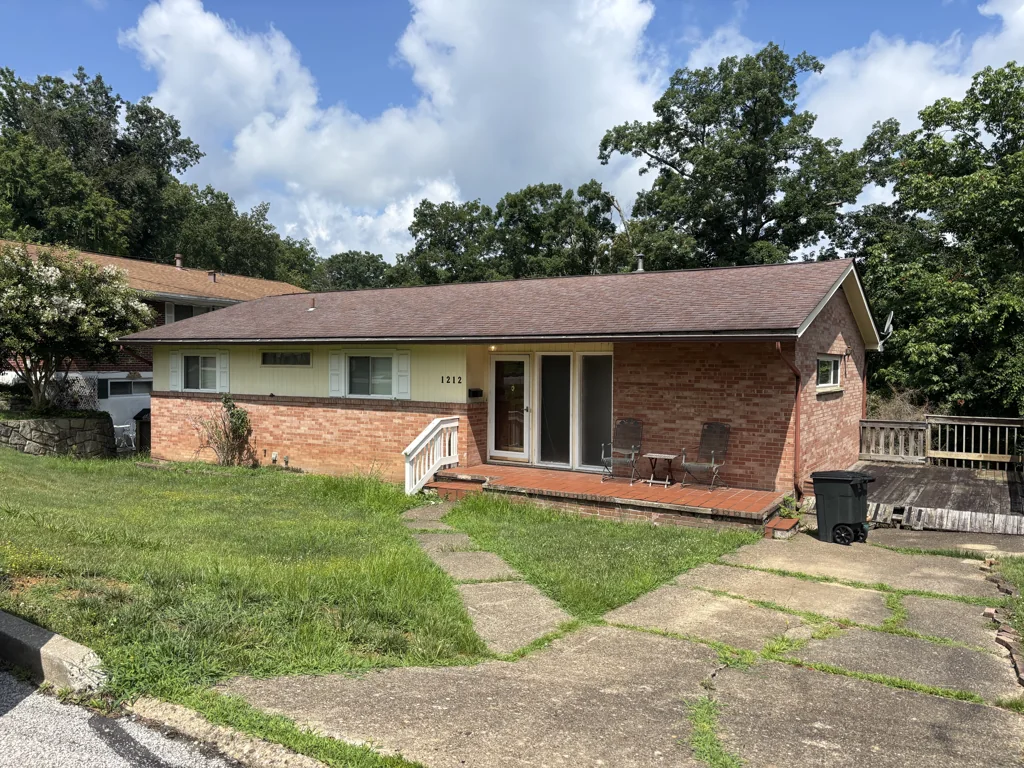 Exterior of 1212 Crown Drive in South Charleston, WV, before work, showing the brick house, front porch and weathered deck