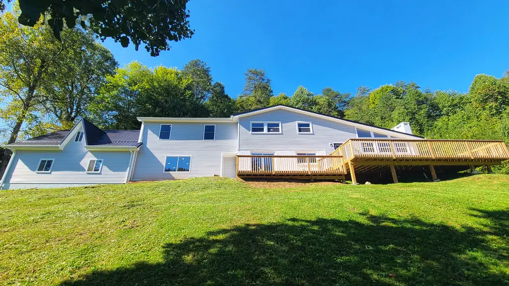 The same Pawnee Drive property after renovation, with light siding and a wood deck