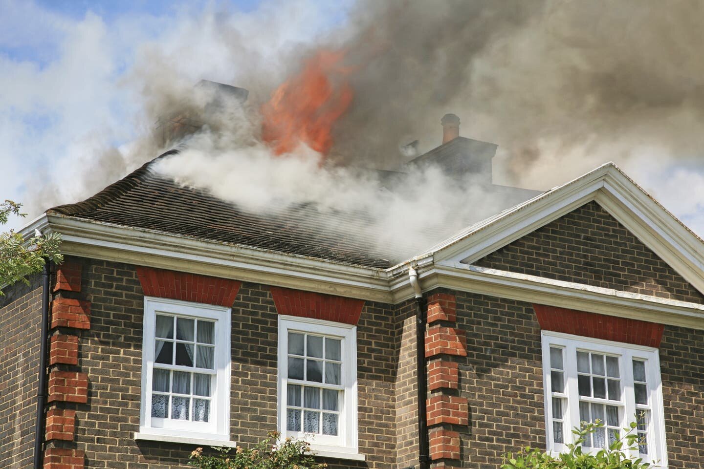 Fire-damaged house interior showing smoke-stained walls and ceiling damage