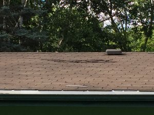 Missing and damaged shingles on roof of fixer upper
