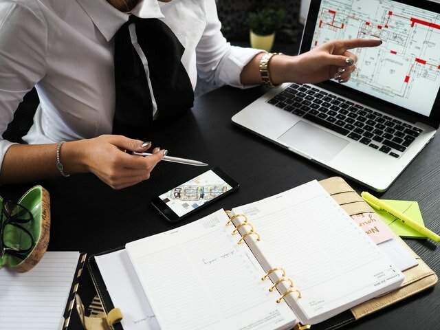 A real estate agent in front of a laptop and open notebook