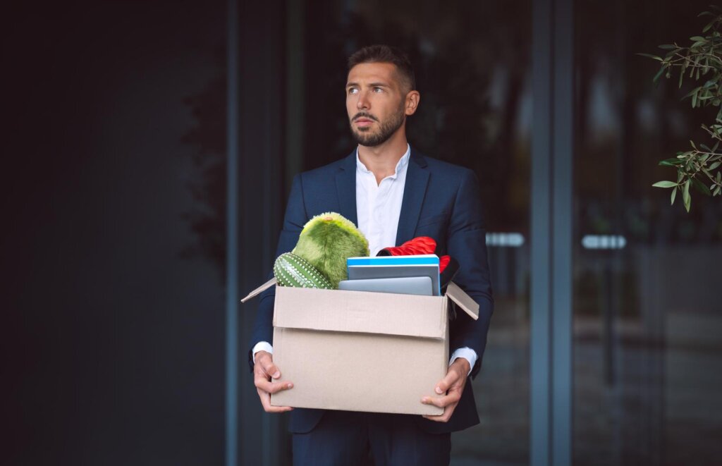 Man carrying a box of personal items out of an office