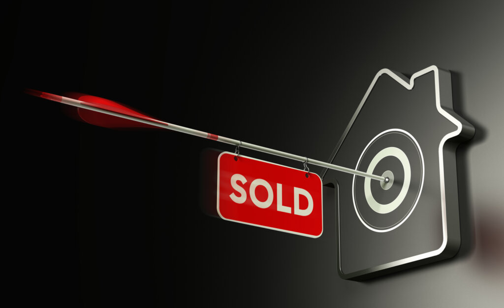 Arrow with sold sign hitting a bullseye
