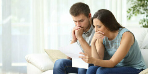 Worried couple reading a letter