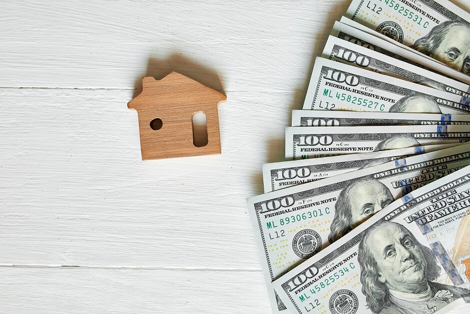 Small wooden house and hundred dollar on white background, concept of real estate, growth of mortgage credit, Property investment and house mortgage financial concept.
