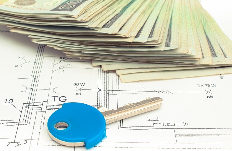 Electrical construction drawings of house, polish currency money and home key, concept of building home cost