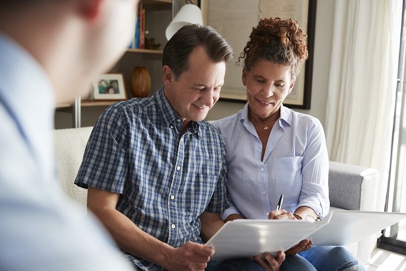 Senior Couple Meeting With Male Financial Advisor At Home