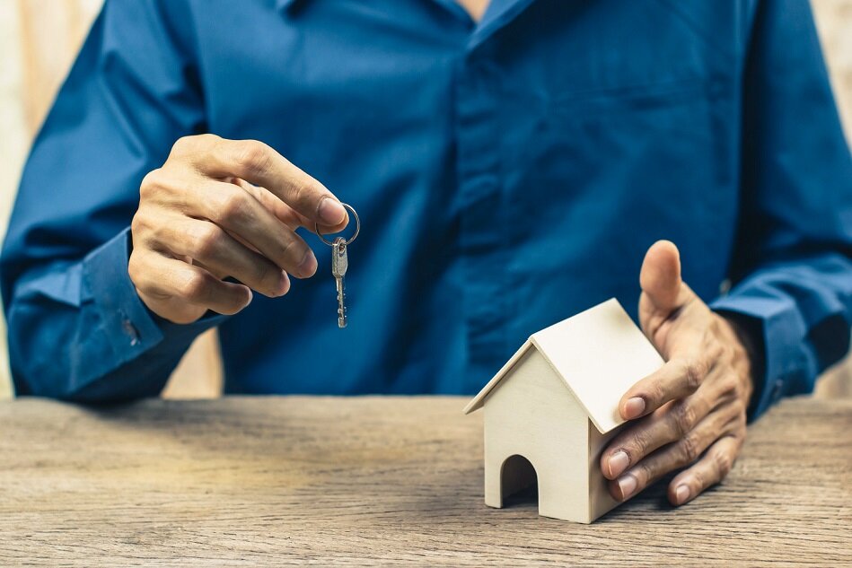 New home buying concept. Estate agent giving house and key. Depicts the completion of the agreement in the home trading.