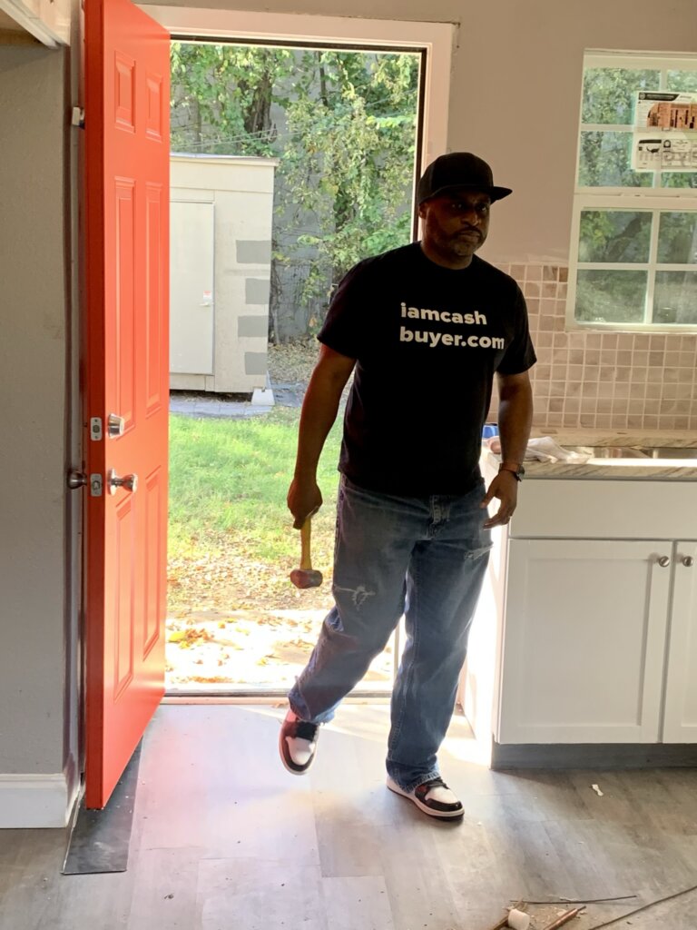 rod hanks walking inside house with hammer