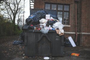 An overfilled dumpster in New Brunswick, NJ. With Templar Real Estate Enterprises, you can sell your house without having to worry about stinky smells!