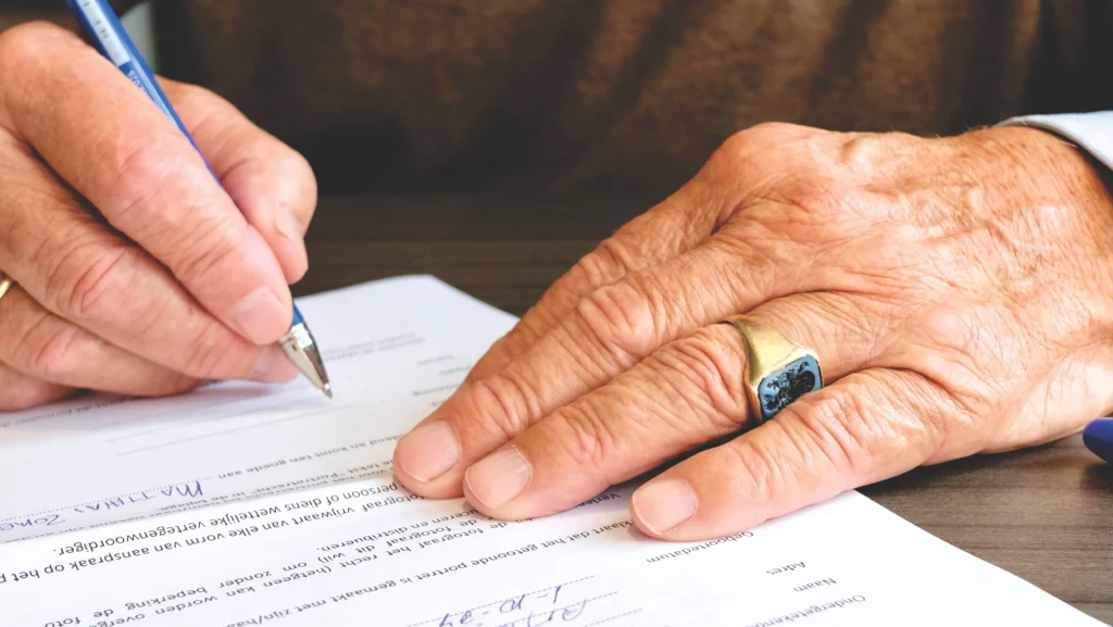 Close-up of hands signing a document