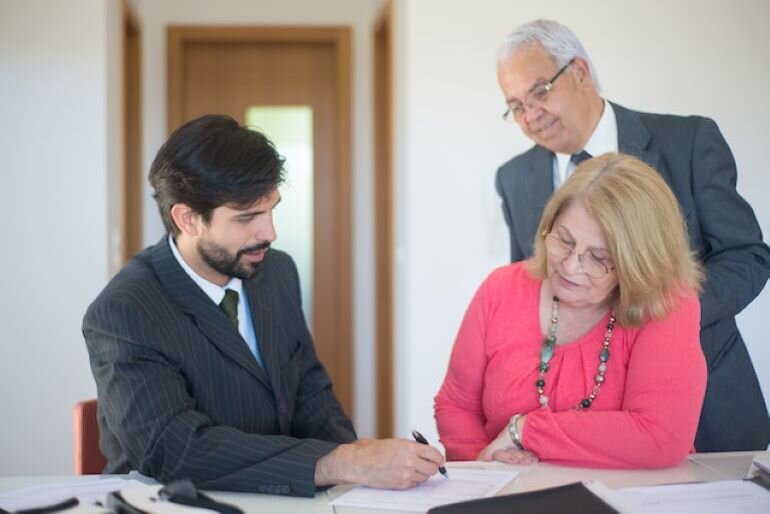 Two people are talking with a real estate agent.