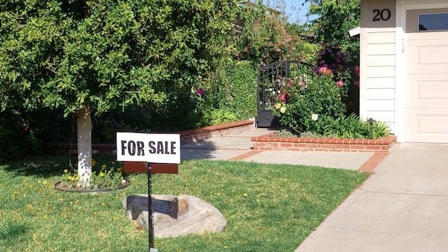 For sale sign in font of a house.