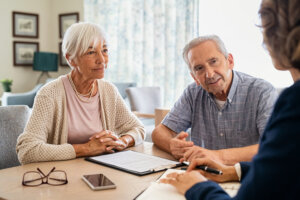 Homeowners meeting with a house buyer to discuss selling their hoarder house.