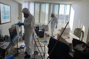 Professional cleaning services clearing out a hoarder house in New Orleans.