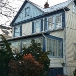 Abandoned vacant house in New Jersey with boarded-up windows, overgrown grass
