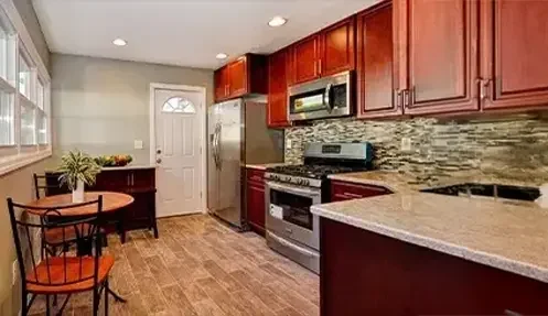 Modern remodeled kitchen with granite countertops, stainless steel appliances, and dark wood cabinetry.