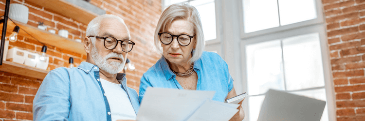 Two elderly homeowners reading about whether or not a house can be sold while in probate