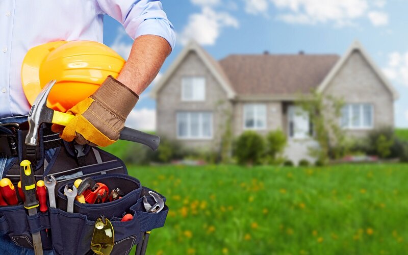 A homeowner stands in front of his property with his toolbelt. Making the necessary repairs is fundamental to sell investment property