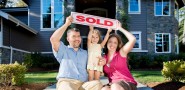 Family holding a sold sign after selling to Sell my house fast Salt Lake City home buying company.
