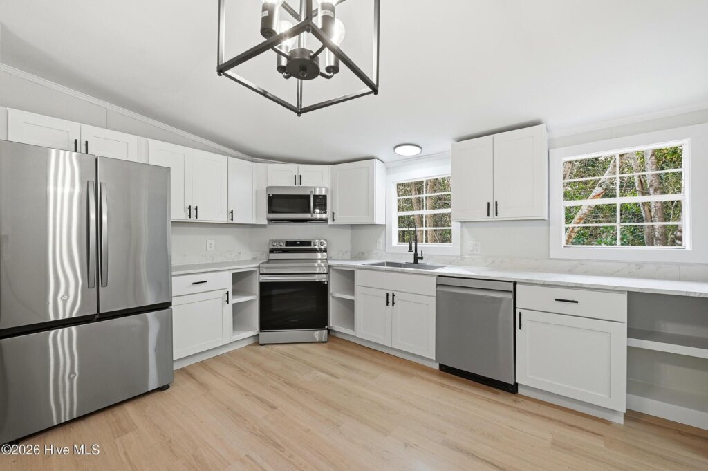 Renovated kitchen with white cabinets and stainless appliances in a Hampstead, NC house